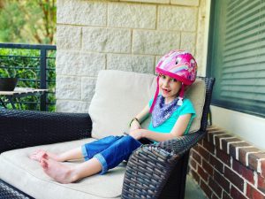 Felicity Frugé sits on a large patio chair and smiles