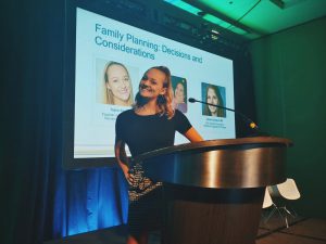Taylor Kane stands behind a podium at the Global Genes conference.